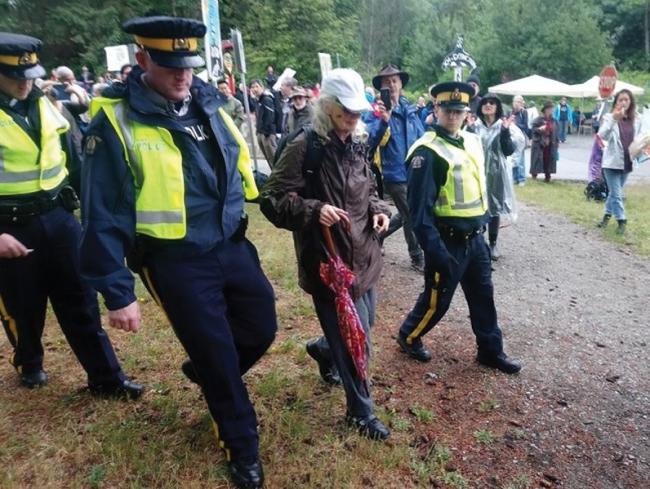 Jean Swanson is accompanied by police during her arrest at the Kinder Morgan terminal in Burnaby. Photo by Riaz Behra.