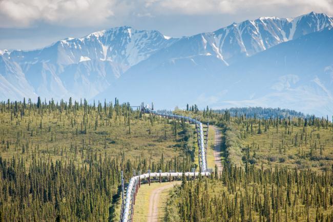 Trans-Alaska Pipeline (Alyeska pipleline) running through landscape with Mountain range in the distance in Alaska. Credit: Edwin Remsburg/VW Pics via Getty Images