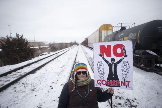 A protester holds a placard as supporters of the Wet'suwet'en hereditary chiefs demonstrate at Macmillan Yard in Toronto, on Feb. 15, 2020.  CHRIS YOUNG/THE CANADIAN PRESS
