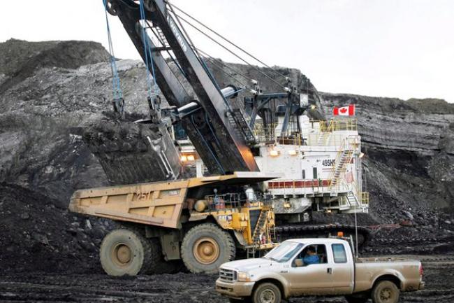 A pickup truck is seen passing a mining shovel at an oil sands mine near Fort McMurray, Alta., in a file photo.  JEFF MCINTOSH/THE CANADIAN PRESS