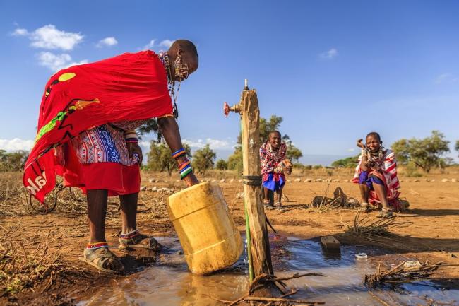 A woman from the Maasai tribe collects water in Kenya, Africa to carry back to the village. hadynyah / E+ / Getty Images