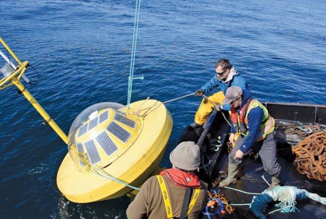 A crew handles a buoy that measures wave energy. Bryson Robertson, UVic adjunct professor of mechanical engineering, said reduced costs alone make wave energy worth examining for Hesquiaht First Nation, since diesel generators are expensive.   Photograph By University of Victoria