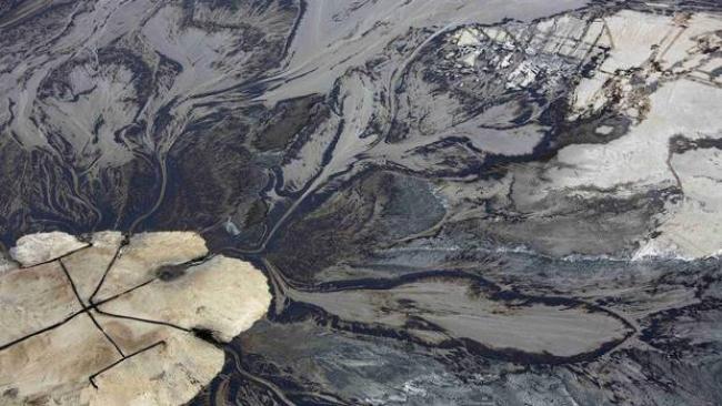 Oil goes into a tailings pond at the Suncor tar sands operations near Fort McMurray, Alberta