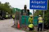 Workers install a sign reading ‘Alligator Alcatraz’ at the entrance to a new migrant detention facility in Florida on July 3, 2025. Photo by Rebecca Blackwell, the Associated Press.