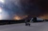 People take their dogs out for a quick break under billowing wildfire smoke off Highway 97 north of Buckinghorse River, BC on Friday, May 30, 2025. File photo by The Canadian Press/Nasuna Stuart-Ulin