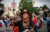 Randy Tait, of the Nisga'a-Gitxsan Nation, blows down feathers into the air during a friendship walk to a National Indigenous Peoples Day gathering, in Vancouver, BC, Wednesday, June 21, 2023. Photo by: Darryl Dyck / The Canadian Press