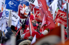 A young child riding on her parents' shoulders is lost in a sea of flags during a huge union protest against the CAQ government in Montreal on Saturday, Nov. 29, 2025. Photo by Allen McInnis /Montreal Gazette