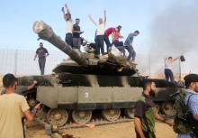 PALESTINIANS TAKE CONTROL OF AN ISRAELI TANK AFTER CROSSING THE BORDER FENCE WITH ISRAEL FROM KHAN YUNIS IN THE SOUTHERN GAZA STRIP ON OCTOBER 7, 2023. (PHOTO: STRINGER/ APA IMAGES)