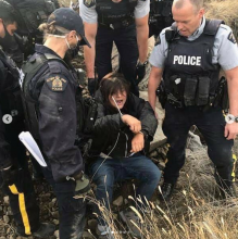 Photo of RCMP violently arresting Sepwecemc land defender blocakding Trans Mountain Drilling under the Thompson River Friday