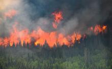 Flames reach upwards along the edge of a wildfire as seen from a Canadian Forces helicopter surveying the area near Mistissini, Quebec, Canada June 12, 2023. CANADIAN FORCES VIA REUTERS