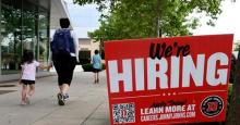 People walk past a "we're hiring" sign posted outside of a restaurant in Arlington, Virginia on June 3, 2022. (Photo: Olivier Douliery/AFP via Getty Images)