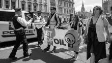 A police officer appears to film Just Stop Oil activists on Whitehall near Parliament Square on Saturday, May 20, 2023. Photo by Alisdare Hickson/Flickr (CC BY-SA 2.0)