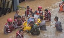  A rescue team evacuates a mother and child after flooding in Jakarta. Photograph: Agung Fatma Putra/SOPA Images/REX/Shutterstock