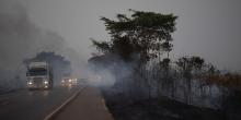 Trucks drive alongside scorched fields on the BR-163 highway in the state of Mato Grosso, Brazil, on Aug. 23, 2019. Photo: Leo Correa/AP