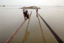 Villagers use part of a damaged railway track to cross floodwaters in Sultan Kot, Sindh province after torrential monsoon rains triggered Pakistan’s worst natural disaster on record in 2010. Photograph: Damir Sagolj/Reuters