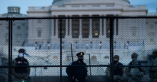 A Capitol Police officer stands with members of the National Guard behind a crowd-control fence surrounding Capitol Hill a day after a pro-Trump mob broke into the U.S. Capitol on January 7, 2021, in Washington, D.C. (Photo: Brendan Smialowski/AFP via Getty Images)