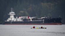 Kayakers paddle past the U.S.-registered tanker "Commitment" anchored on Burrard Inlet in North Vancouver, B.C., waiting to load at Kinder Morgan's Westridge Marine Terminal on the south shore of Burrard Inlet in Burnaby on Thursday May 3, 2012. (DARRYL DYCK for the Globe and Mail)