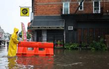 A person pushes a barricade floating on a flooded street amid a coastal storm on September 29, 2023, in the Flatbush neighborhood of Brooklyn, N.Y. (Michael M. Santiago / Getty)