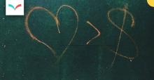Graffiti - heart greater than dollar sign - Photo by Jon Tyson on Unsplash