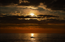 An early rising sport fisherman motors over calm seas on his way to striped bass fishing grounds off the coast of Kennebunkport, Maine, on July 7.Robert F. Bukaty / AP