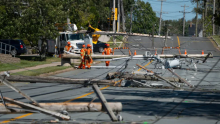 Workers assess downed lines and poles caused by post-tropical storm Fiona in Dartmouth, N.S., on Sept. 25. (Darren Calabrese/The Canadian Press)