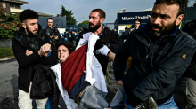 Plainclothes police officers detain a demonstrator as climate activists from Extinction Rebellion, Scientist Rebellion and Last Generation block the entrance of an airport facility in Milan on Nov. 10, 2022. (Piero Cruciatti/AFP/Getty Images)