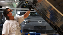 Volkswagen's new battery plant in St. Thomas, Ont., could soon be making up to 1 million batteries a year, which will be used across the company's supply chain, including at this VW plant in Dresden, Germany where a worker is attaching an EV battery to an electric vehicle. (Liesa Johannssen-Koppitz/Bloomberg)
