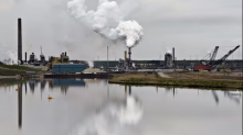 An oilsands extraction facility is reflected in a tailings pond near the city of Fort McMurray, Alta., in this file photo. (Jason Franson/The Canadian Press)