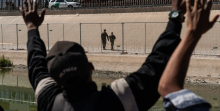 Asylum-seeking migrants waving their hands at National Guardsmen near the Rio Grande before crossing into the United States in March.The Biden administration fears that the lifting of a public health rule that allowed officials to quickly expel migrants could lead to an increase in border crossings.Credit...Go Nakamura for The New York Times