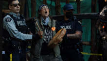 Uncle Rico continues to sing and drum as RCMP CIRG officers arrest them at Savage Patch, a camp blockading old growth logging, in Pacheedaht territory near Port Renfrew, British Columbia. All photos by Amber Bracken