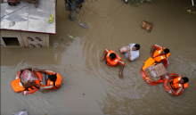 National Disaster Response Force personnel distribute relief material to people stuck in flooding near the river Yamuna, New Delhi, July 2023. Photograph: Manish Swarup/AP