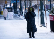 A woman covers her face walking down the street as freezing temperatures as low as -38 C hit the city of Calgary, Alta., Monday, Jan. 15, 2024. THE CANADIAN PRESS/Todd Korol