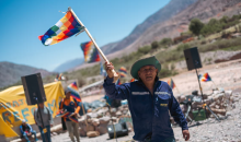 A man carries the Wiphala flag – which represents the native peoples of the Andes – at the protest camp in Purmamarca, Jujuy province. The demonstrators, many of them from the Indigenous community, are angry about changes made to the state constitution, and the growth of mining. Photograph: John Owens