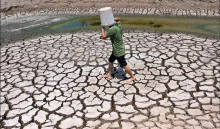 A man shields from the sun as he crosses a dried-up pond in Vietnam in March, which was recorded as the hottest month globally on record. Photograph: Nhac Nguyen/AFP/Getty Images