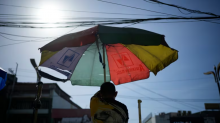 A vendor prepares his umbrella as hot days continue in Manila, Philippines. Sizzling heat across Asia and the Middle East in late April that echoed last year’s destructive swelter was made more likely because of human-caused climate change, a study found. (Aaron Favila/The Associated Press)