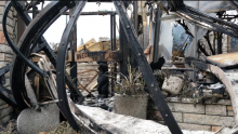 The collapsed entrance of the L&W restaurant after a wildfire in Jasper, Alta., earlier this year. A wildfire in the mountain town saw insured losses of $880 million. (Josh McLean/CBC)