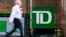 Four Canadian banks have joined several U.S. banks in pulling out of a global alliance that supports efforts to align lending, investment and other financial activities with the goal of achieving net-zero greenhouse gas emissions by 2050. A person makes their way past a Toronto-Dominion Bank branch in Toronto, Monday, Aug. 14, 2023. (Spencer Colby/The Canadian Press)