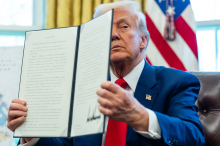 President Trump held up an executive order at a signing ceremony in the Oval Office this month.Credit...Eric Lee/The New York Times