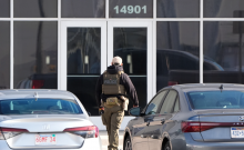 A US Immigration and Customs Enforcement agent stands outside a warehouse being toured for repurposing into a detention facility in Kansas City, Missouri, on Thursday, Jan. 15, 2026. ICE is seeking a Hanover County building for immigrant processing.