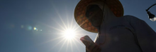 A person wears a hat for shade under the morning sun while walking along The Strand in Redondo Beach, California on March 20, 2026, during a heatwave. (Photo by Patrick T. Fallon/AFP via Getty Images)