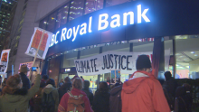 Protesters stand outside a Vancouver, B.C. bank on Dec. 1, 2016. (CBC)
