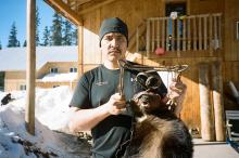 Johnny Morris, Gidimt'en Clan, poses with a wolverine in front of the Unist'ot'en Healing Centre. Trapping and other land based cultural activities are part of Healing Centre programming. Photo by Michael Toledano