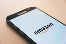 Cell phone with amazon logo - Amazon's rise in corporate power exemplifies monopolistic business practices, the public subsidization of corporations, and the corporate assault on public health and the ecological integrity of the Earth.